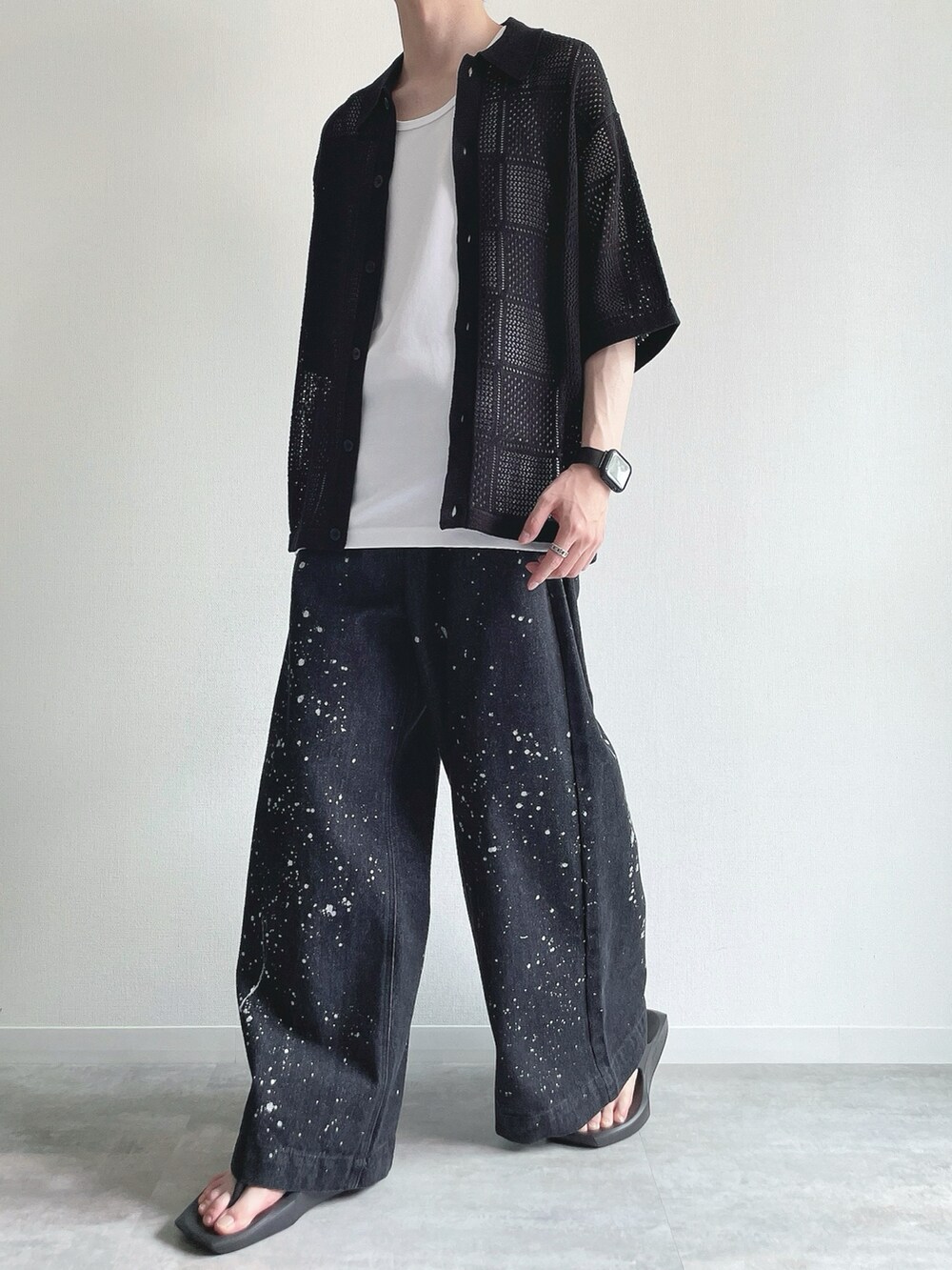 ブラック系のトップス、ホワイト系のタンクトップ、ブラック系のデニムパンツを着用したメンズの夏コーディネートの5枚目の写真