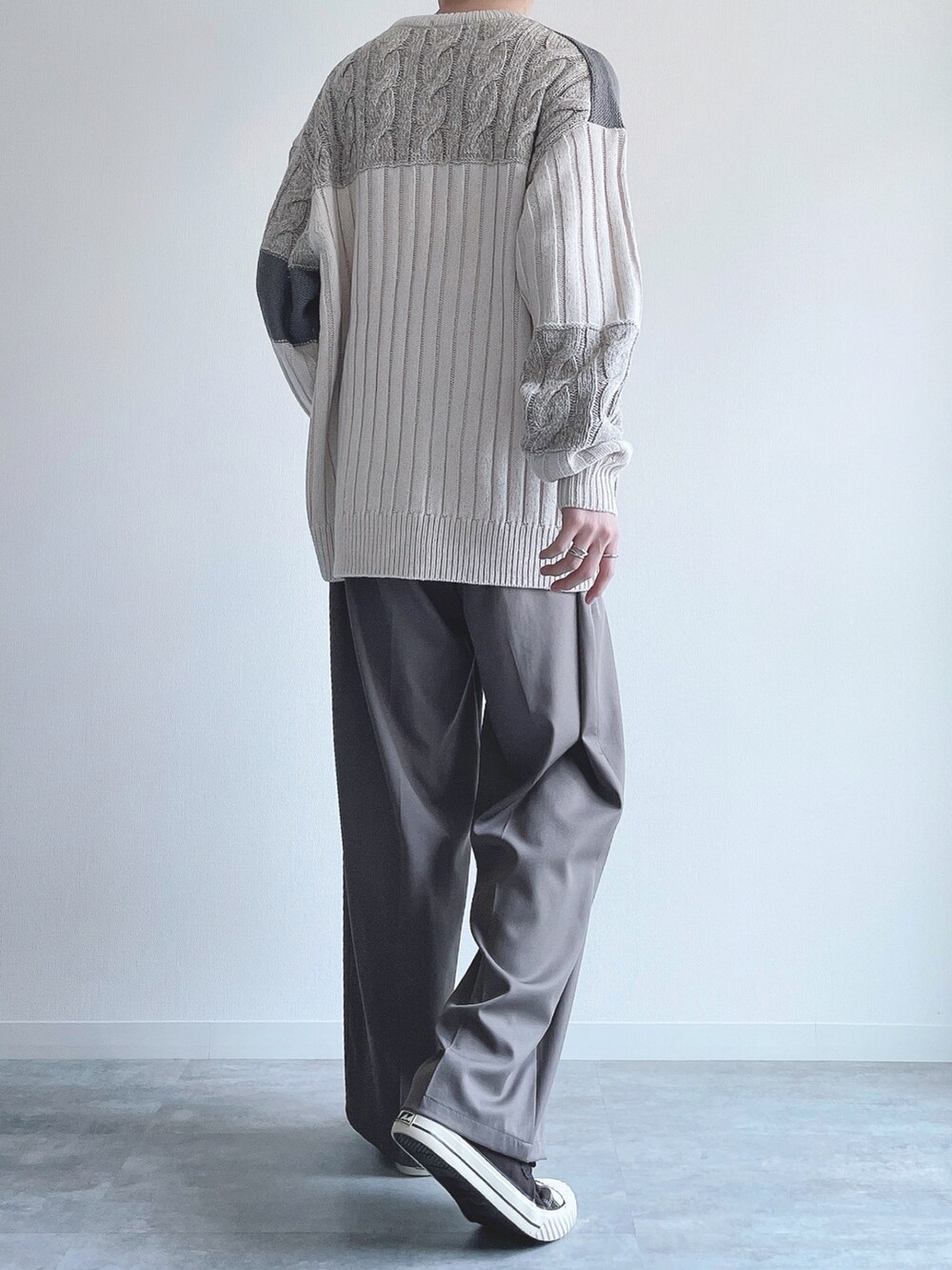 ホワイト系のニット/セーター、ベージュ系のスラックス、ブラウン系のスニーカーを着用したメンズの冬コーディネートの3枚目の写真