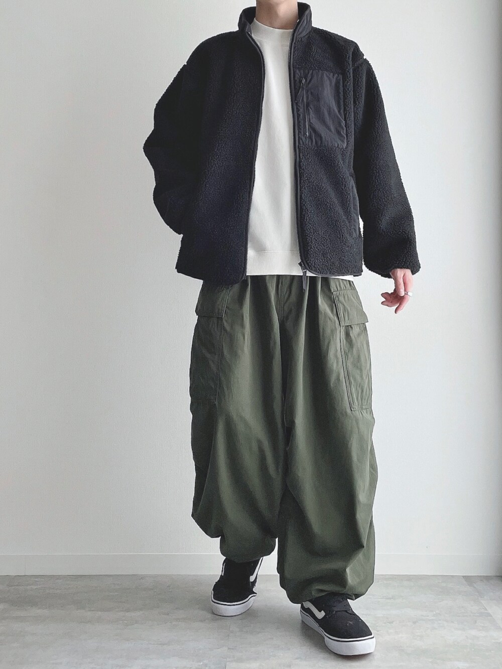 ブラック系のジャケット/アウター、ホワイト系のスウェット、グリーン系のカーゴパンツを着用したメンズの冬コーディネートの4枚目の写真