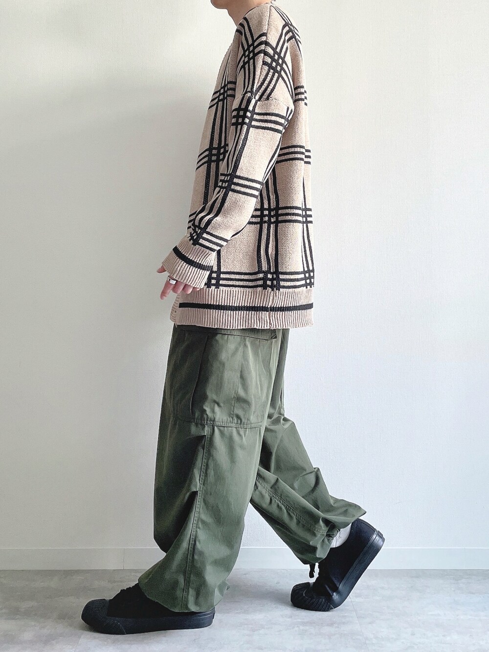 ベージュ系のカーディガン/ボレロ、ホワイト系のTシャツ/カットソー、グリーン系のカーゴパンツを着用したメンズの春コーディネートの3枚目の写真