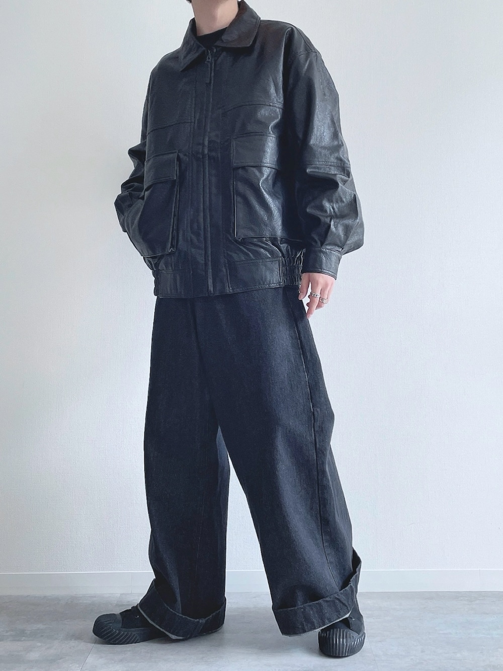 ブラック系のブルゾン、ブラック系のTシャツ/カットソー、ブラック系のデニムパンツを着用したメンズの冬コーディネートの5枚目の写真