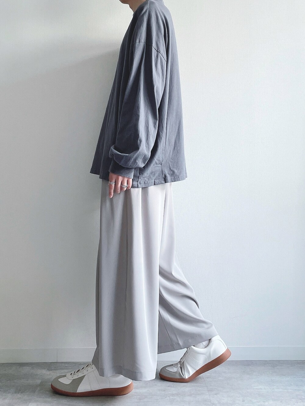 ブルー系のTシャツ/カットソー、グレー系のスラックス、ホワイト系のスニーカーを着用したメンズの秋コーディネートの3枚目の写真