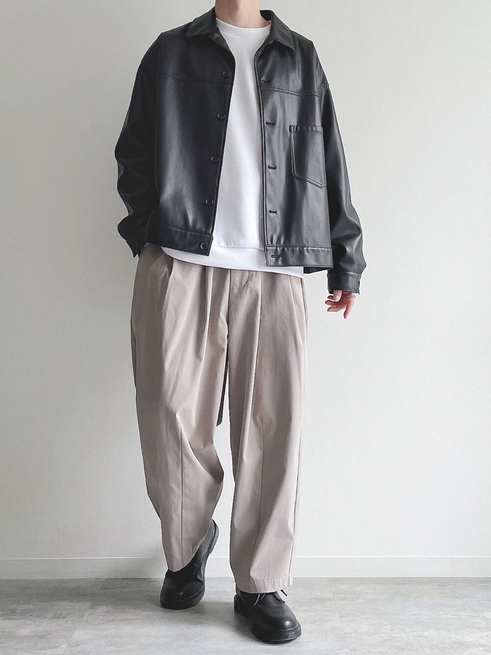 ブラック系のブルゾン、ホワイト系のトップス、ベージュ系のその他パンツを着用したメンズの冬コーディネートの2枚目の写真