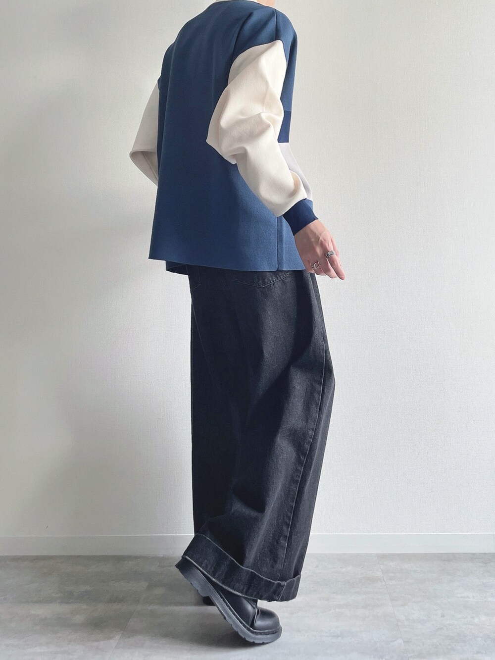 ブルー系のポロシャツ、ブラック系のデニムパンツ、ブラック系のシューズを着用したメンズの秋コーディネートの4枚目の写真