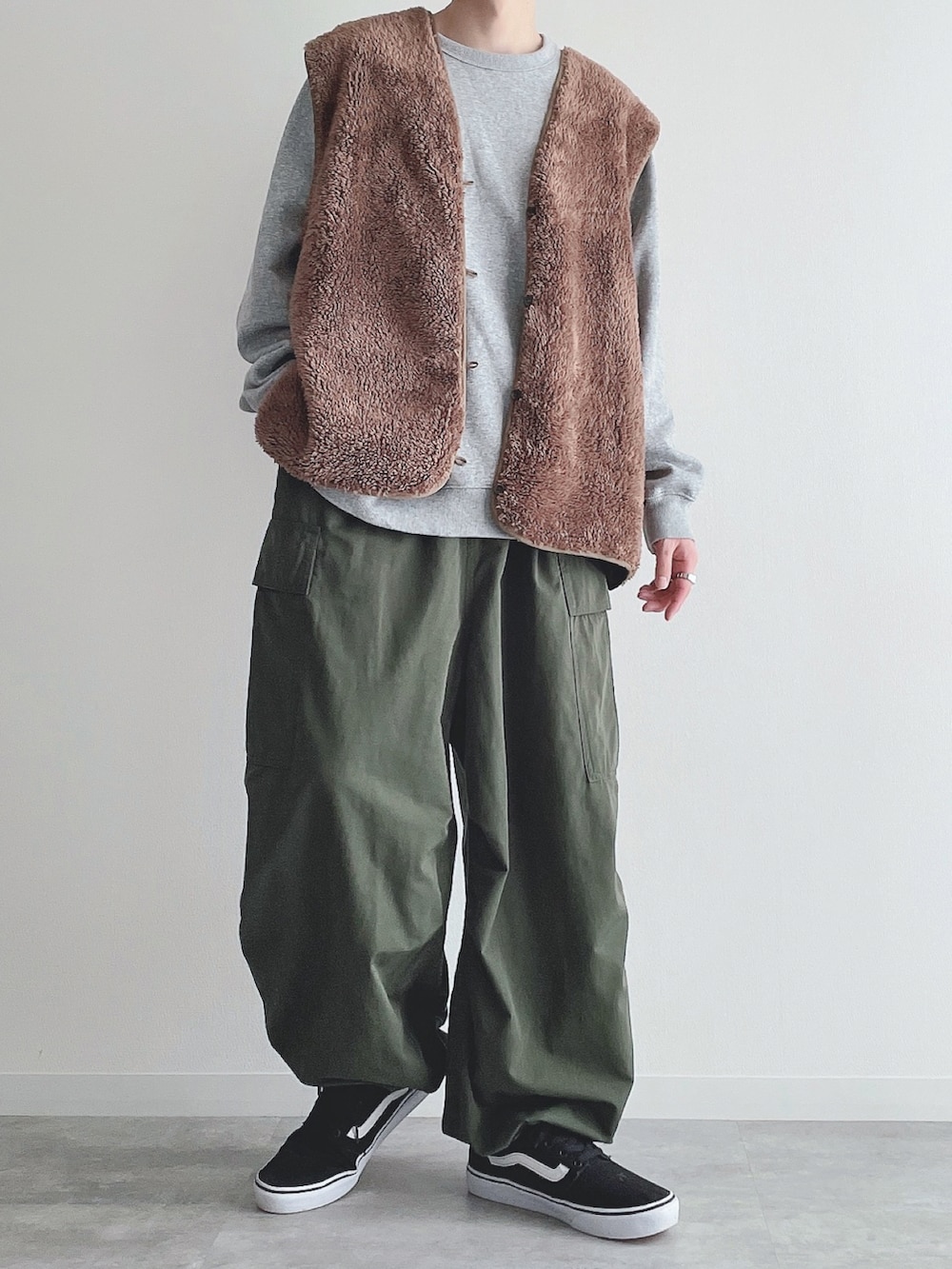 ブラウン系のベスト、グレー系のトップス、グリーン系のカーゴパンツを着用したメンズの秋コーディネートの5枚目の写真