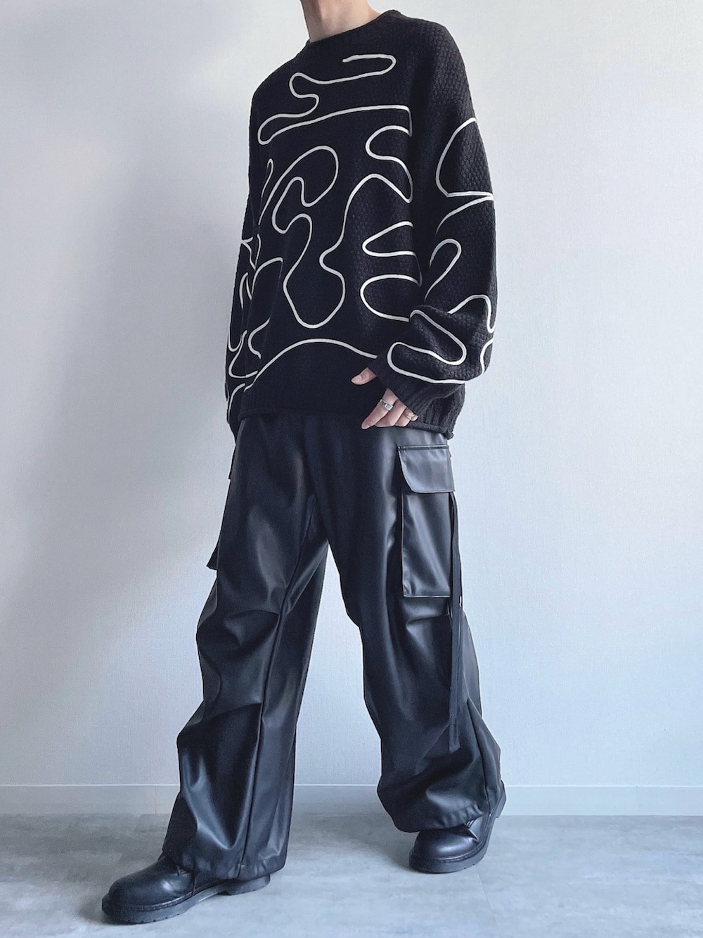 ブラック系のニット/セーター、ブラック系のカーゴパンツ、ブラック系のシューズを着用したメンズの冬コーディネートの5枚目の写真