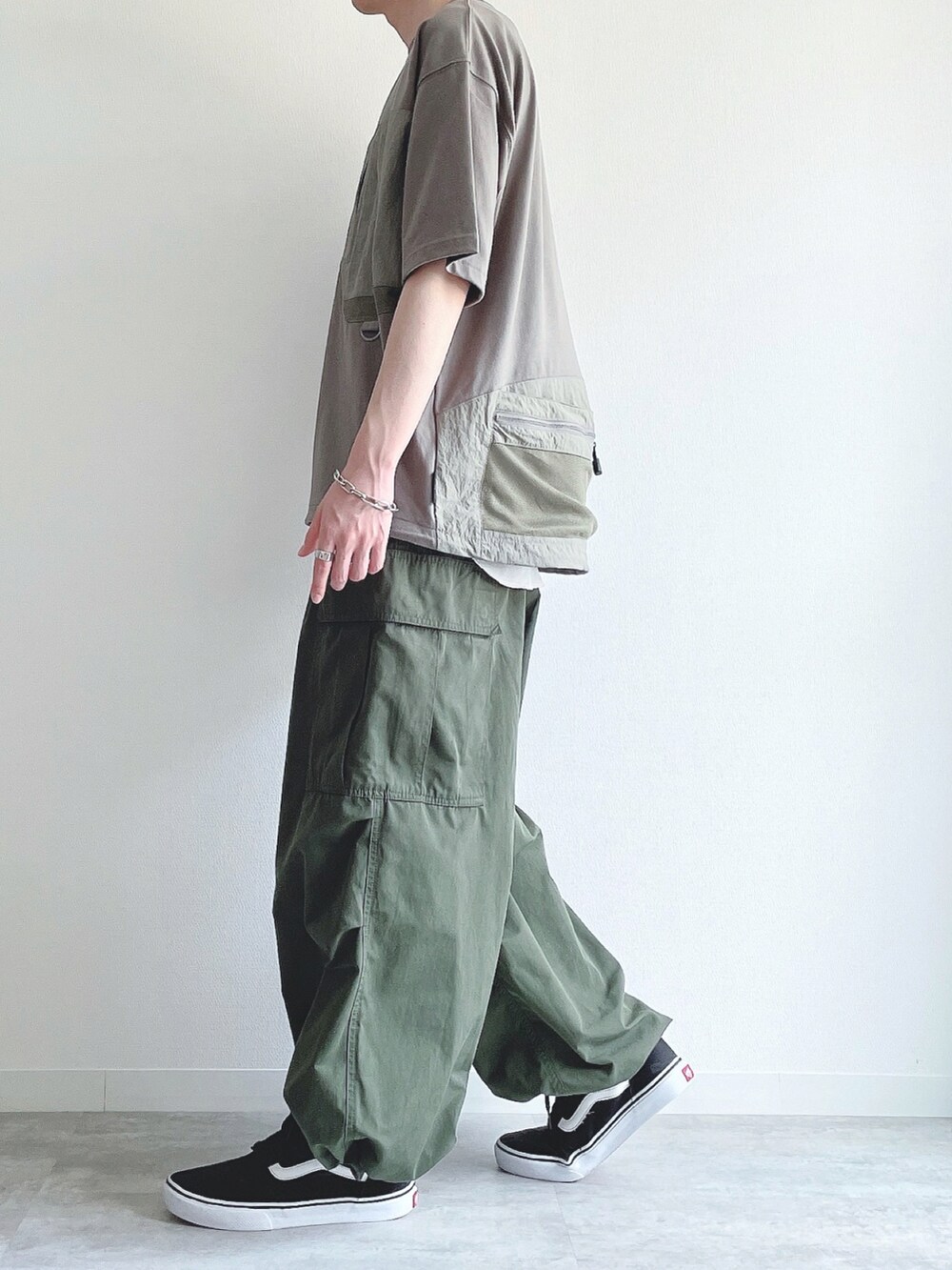 グリーン系のTシャツ/カットソー、ホワイト系のタンクトップ、グリーン系のカーゴパンツを着用したメンズの春コーディネートの3枚目の写真