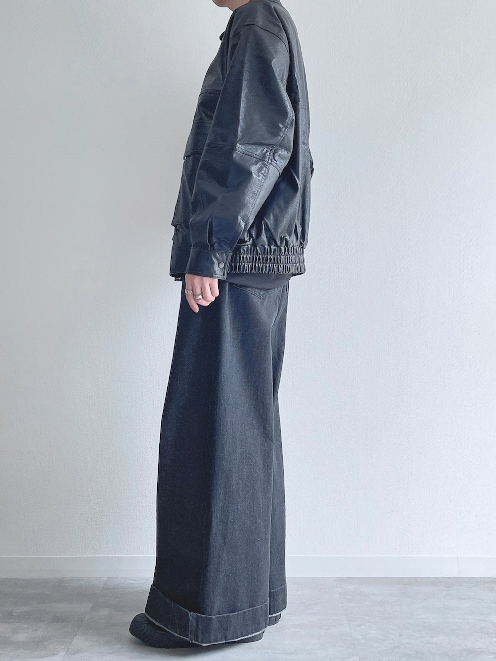 ブラック系のブルゾン、ブラック系のTシャツ/カットソー、ブラック系のデニムパンツを着用したメンズの冬コーディネートの3枚目の写真