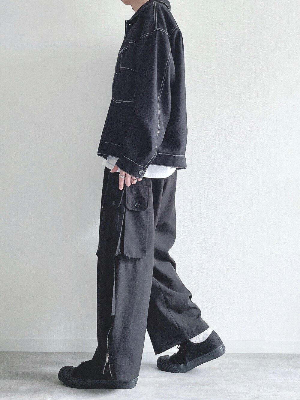 ブラック系のブルゾン、ホワイト系のTシャツ/カットソー、ブラック系のカーゴパンツを着用したメンズの秋コーディネートの3枚目の写真