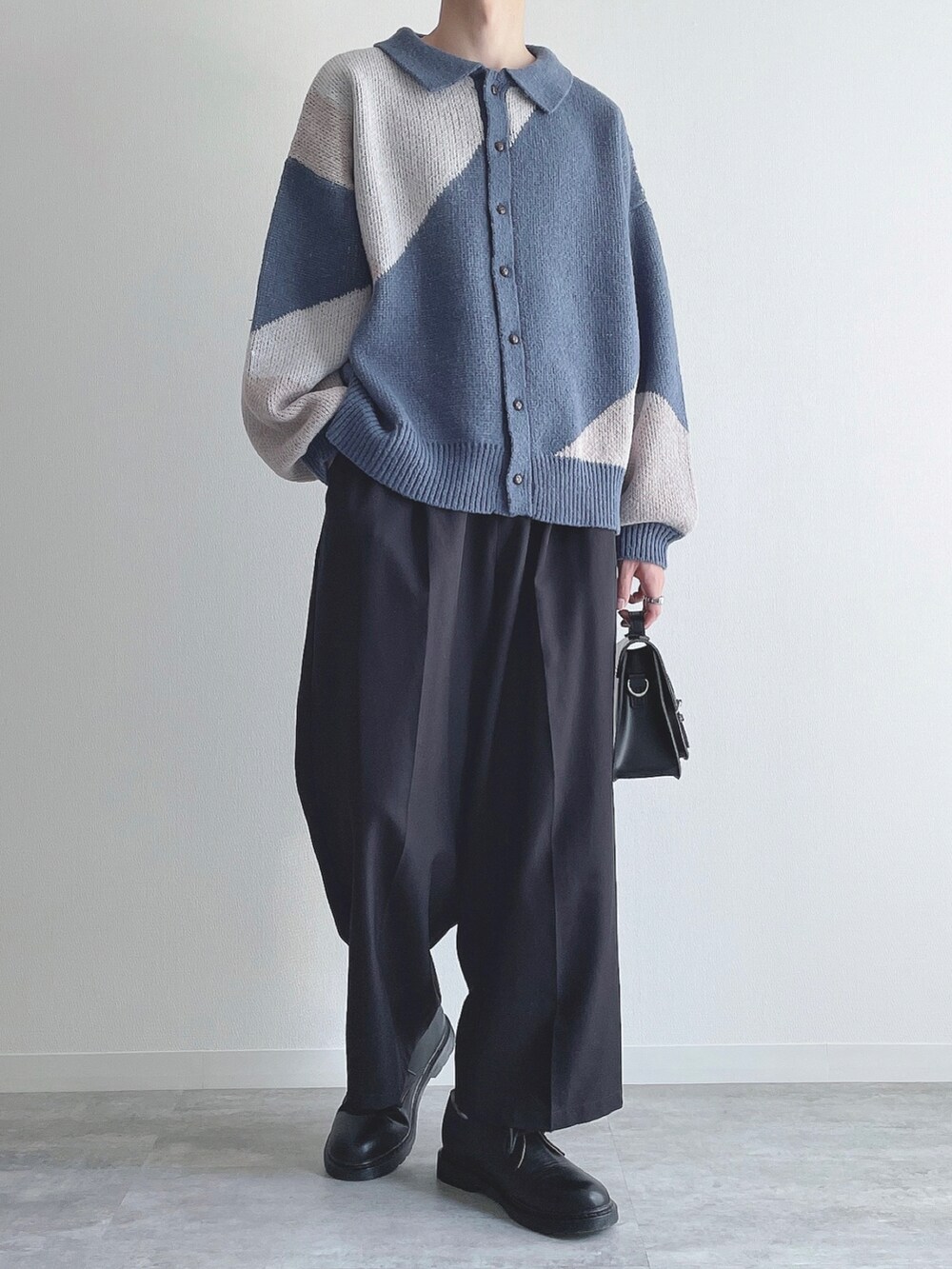 ブルー系のカーディガン/ボレロ、ブラック系のスラックス、ブラック系のドレスシューズを着用したメンズの秋コーディネートの5枚目の写真