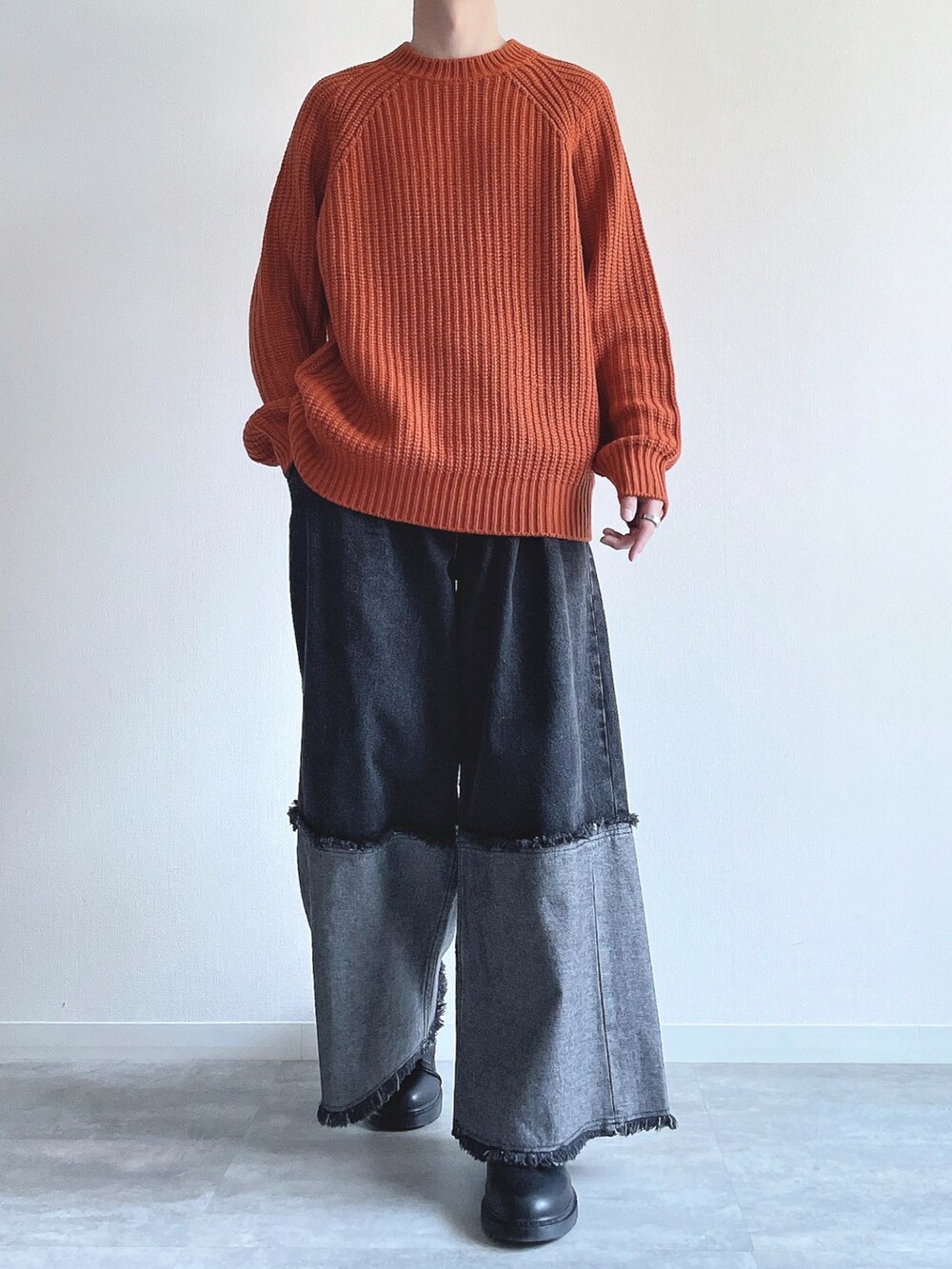 オレンジ系のトップス、ブラック系のデニムパンツ、ブラック系のスニーカーを着用したメンズの冬コーディネートの2枚目の写真