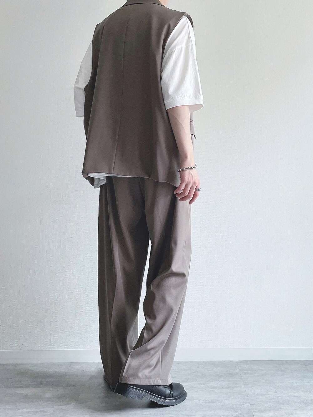 ベージュ系のベスト、ホワイト系のTシャツ/カットソー、ベージュ系のスラックスを着用したメンズの夏コーディネートの4枚目の写真