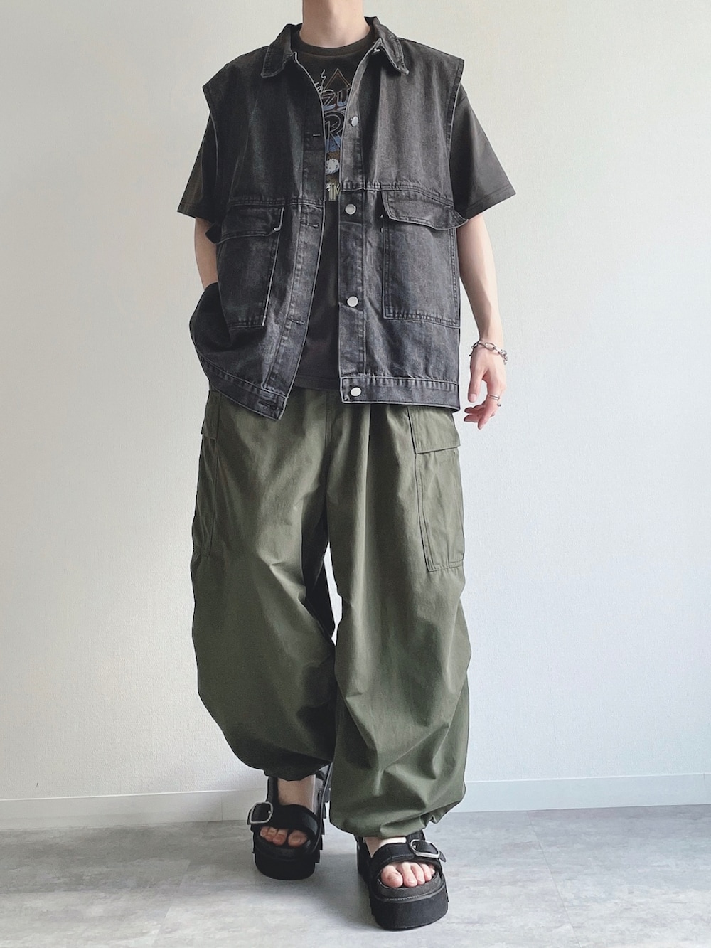 ブラック系のベスト、ブラック系のTシャツ/カットソー、グリーン系のカーゴパンツを着用したメンズの夏コーディネートの2枚目の写真