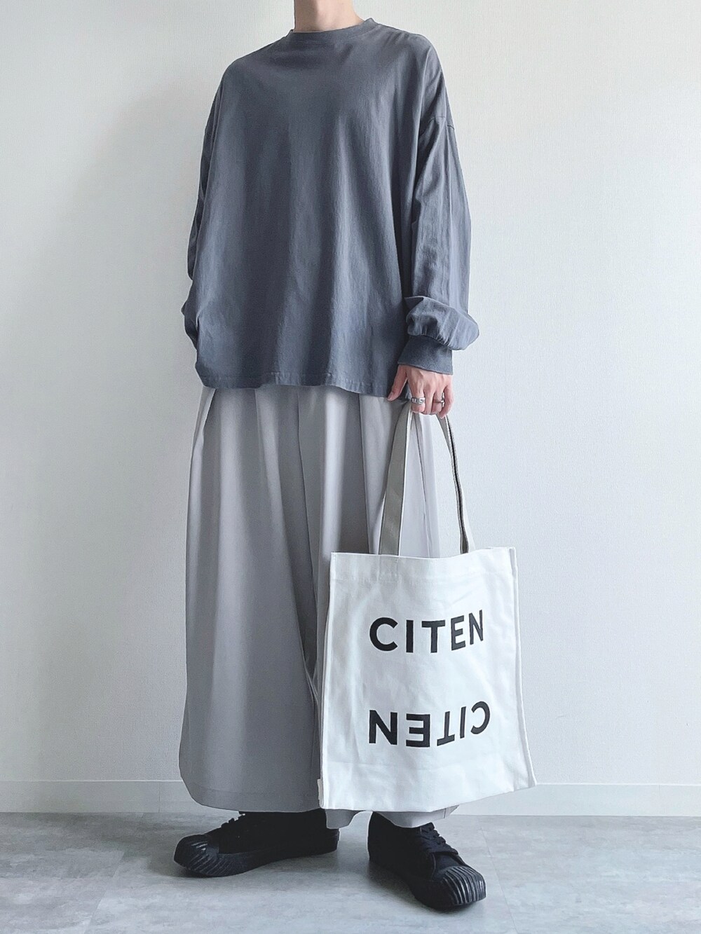 ブルー系のTシャツ/カットソー、グレー系のスラックス、ブラック系のスニーカーを着用したメンズの秋コーディネートの5枚目の写真