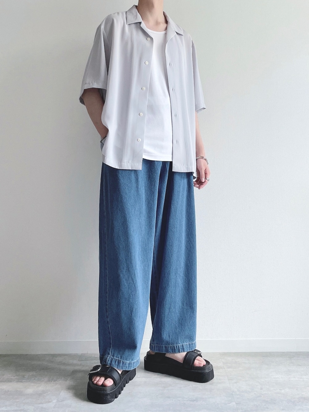 グレー系のトップス、ホワイト系のタンクトップ、ブルー系のデニムパンツを着用したメンズの夏コーディネートの5枚目の写真