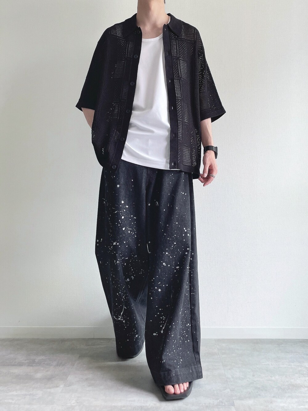 ブラック系のトップス、ホワイト系のタンクトップ、ブラック系のデニムパンツを着用したメンズの夏コーディネートの2枚目の写真