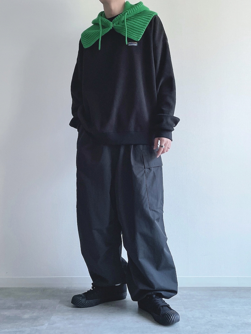 ブラック系のスウェット、ブラック系のカーゴパンツ、ブラック系のスニーカーを着用したメンズの冬コーディネートの4枚目の写真