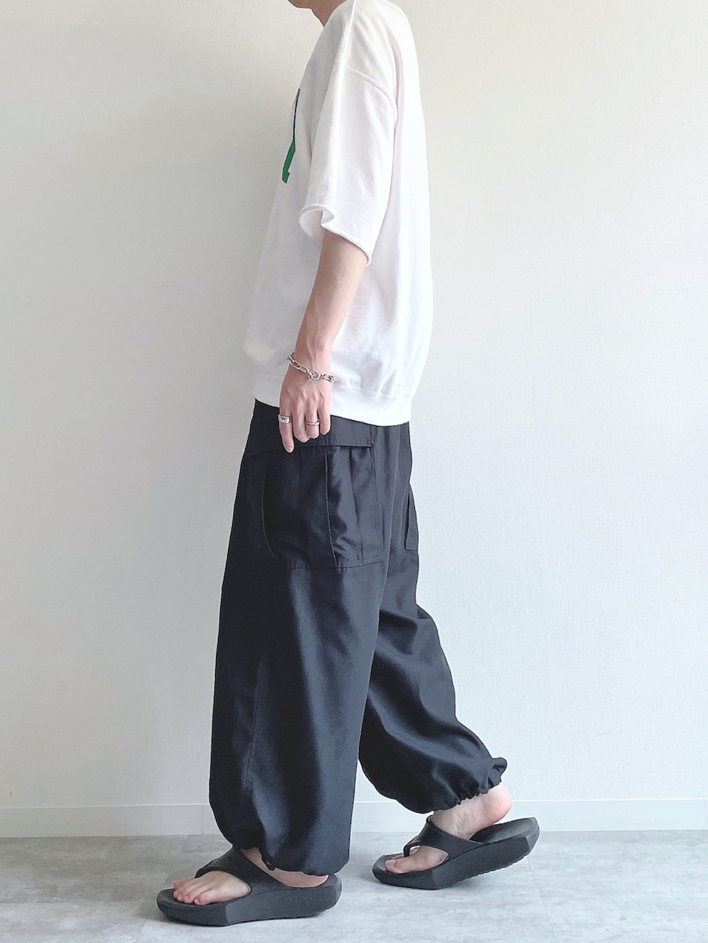 ホワイト系のTシャツ/カットソー、ブラック系のその他パンツ、ブラック系のサンダルを着用したメンズの夏コーディネートの2枚目の写真