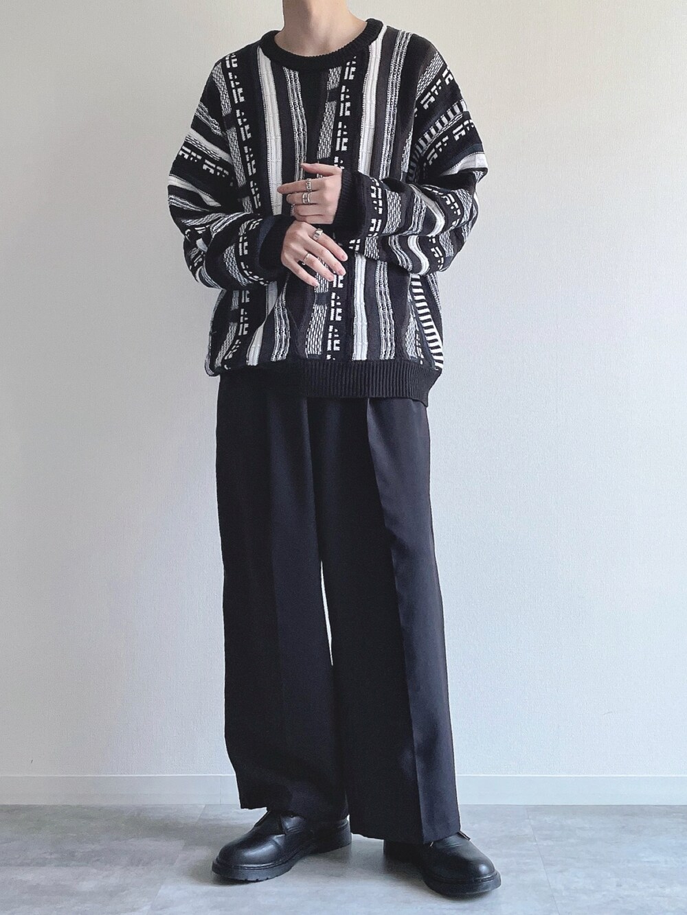 ブラック系のニット/セーター、ブラック系のスラックス、ブラック系のシューズを着用したメンズの冬コーディネートの5枚目の写真