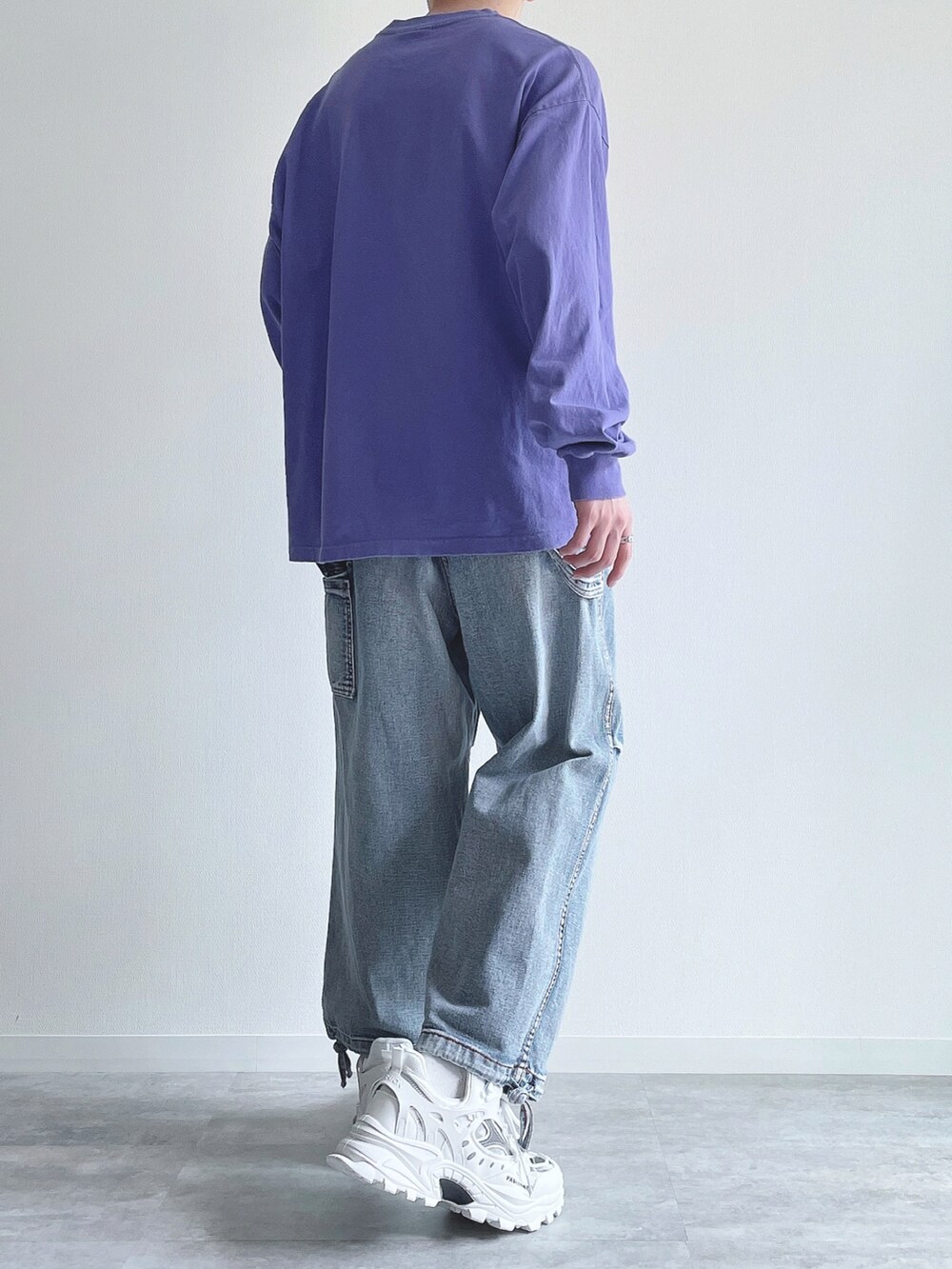 パープル系のTシャツ/カットソー、ブルー系のデニムパンツ、ホワイト系のスニーカーを着用したメンズの春コーディネートの3枚目の写真