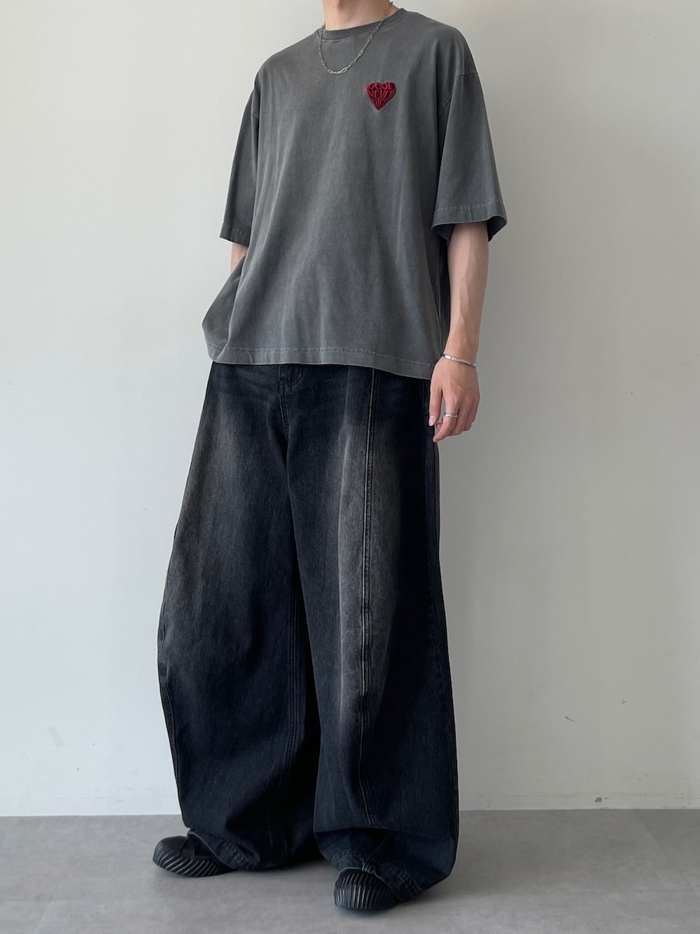 ブラック系のTシャツ/カットソー、ブラック系のデニムパンツ、ブラック系のスニーカーを着用したメンズの夏コーディネートの5枚目の写真