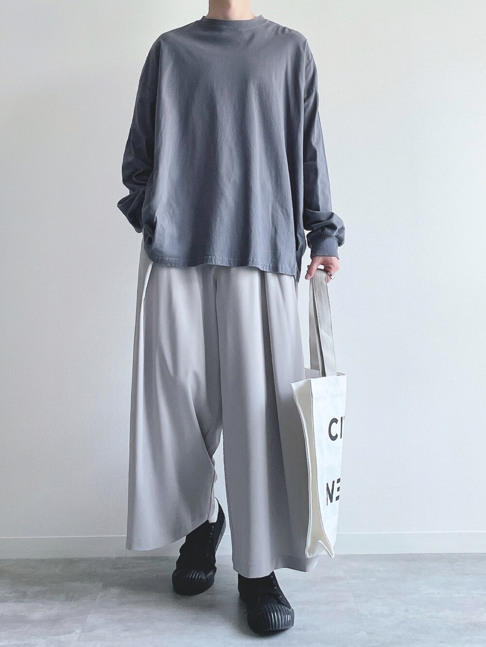 ブルー系のTシャツ/カットソー、グレー系のスラックス、ブラック系のスニーカーを着用したメンズの秋コーディネートの2枚目の写真