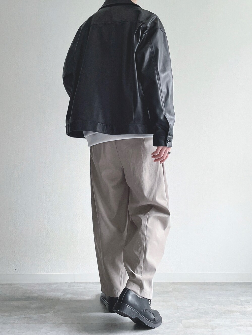 ブラック系のブルゾン、ホワイト系のトップス、ベージュ系のその他パンツを着用したメンズの冬コーディネートの4枚目の写真