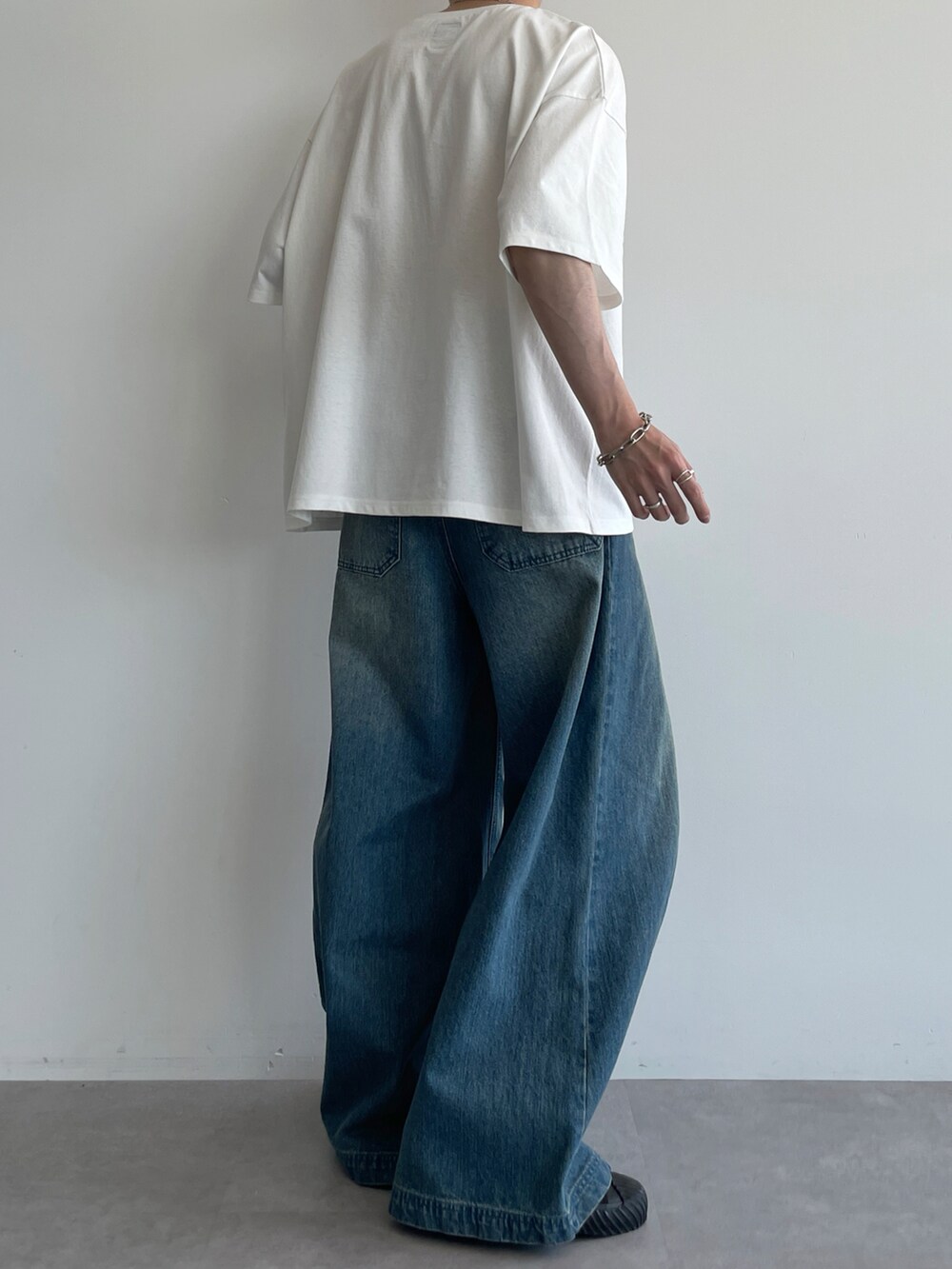 ホワイト系のTシャツ/カットソー、ブルー系のデニムパンツ、ブラック系のスニーカーを着用したメンズの夏コーディネートの3枚目の写真