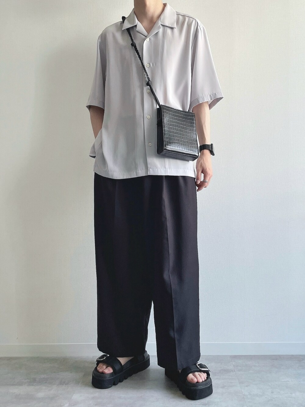 グレー系のトップス、ホワイト系のタンクトップ、ブラック系のスラックスを着用したメンズの夏コーディネートの5枚目の写真