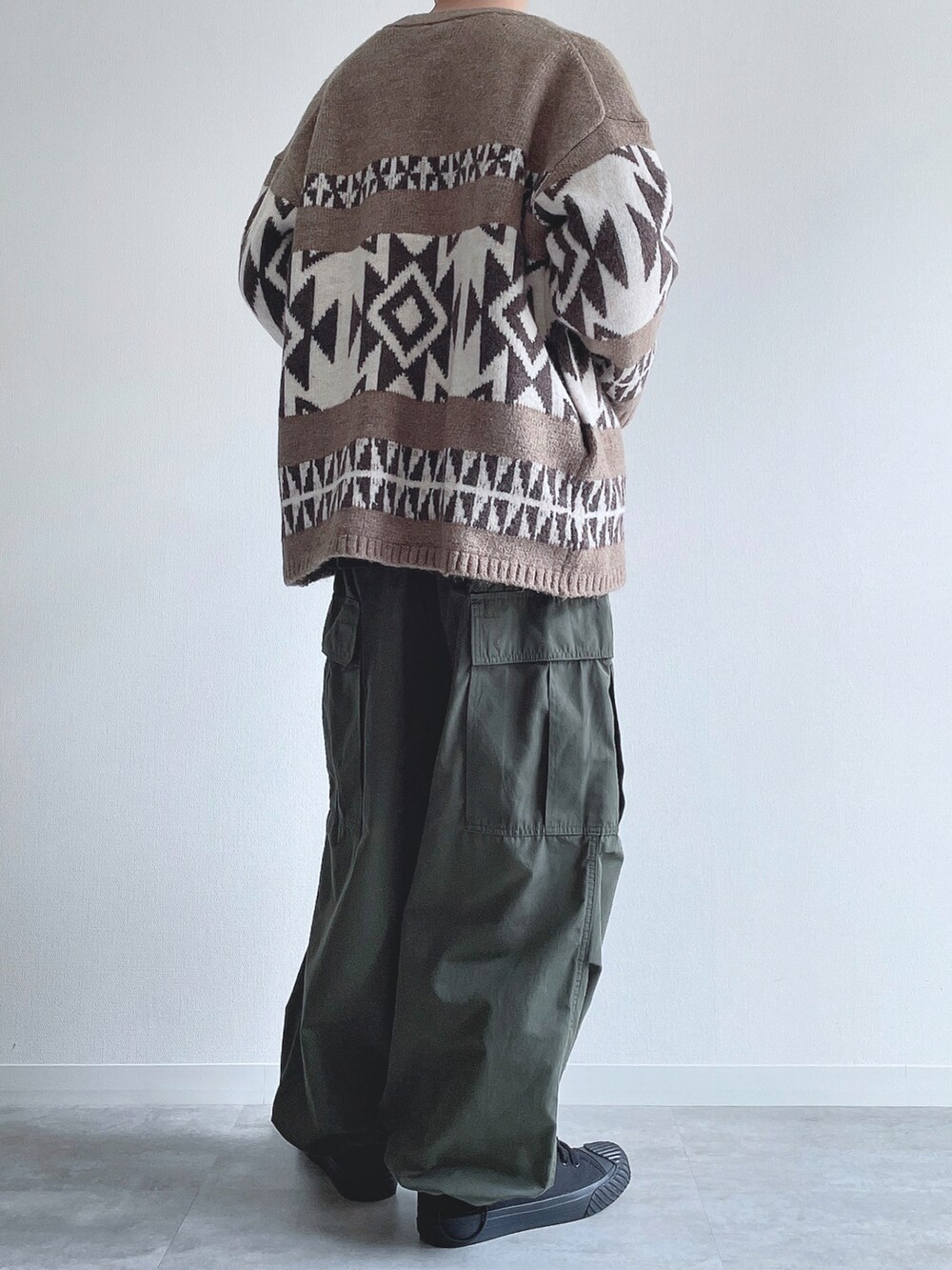 ベージュ系のカーディガン/ボレロ、ブラック系のスウェット、グリーン系のカーゴパンツを着用したメンズの冬コーディネートの4枚目の写真