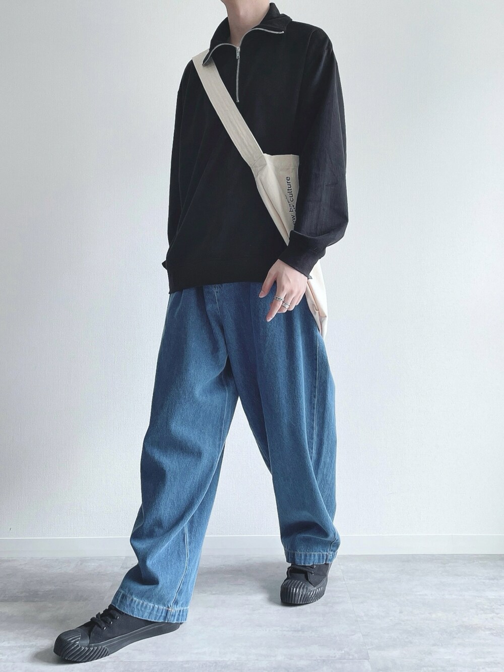 ブラック系のスウェット、ブルー系のデニムパンツ、ブラック系のスニーカーを着用したメンズの秋コーディネートの5枚目の写真