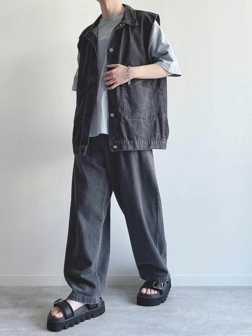 ブラック系のベスト、ブルー系のTシャツ/カットソー、ブラック系のデニムパンツを着用したメンズの夏コーディネートの5枚目の写真