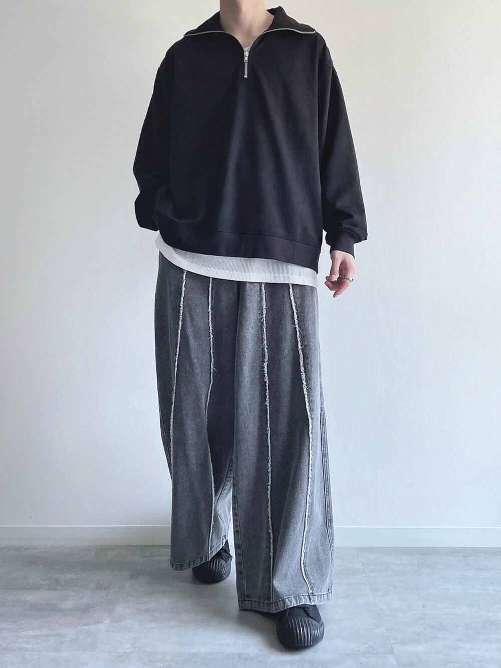 ブラック系のスウェット、ホワイト系のタンクトップ、グレー系のデニムパンツを着用したメンズの春コーディネートの2枚目の写真