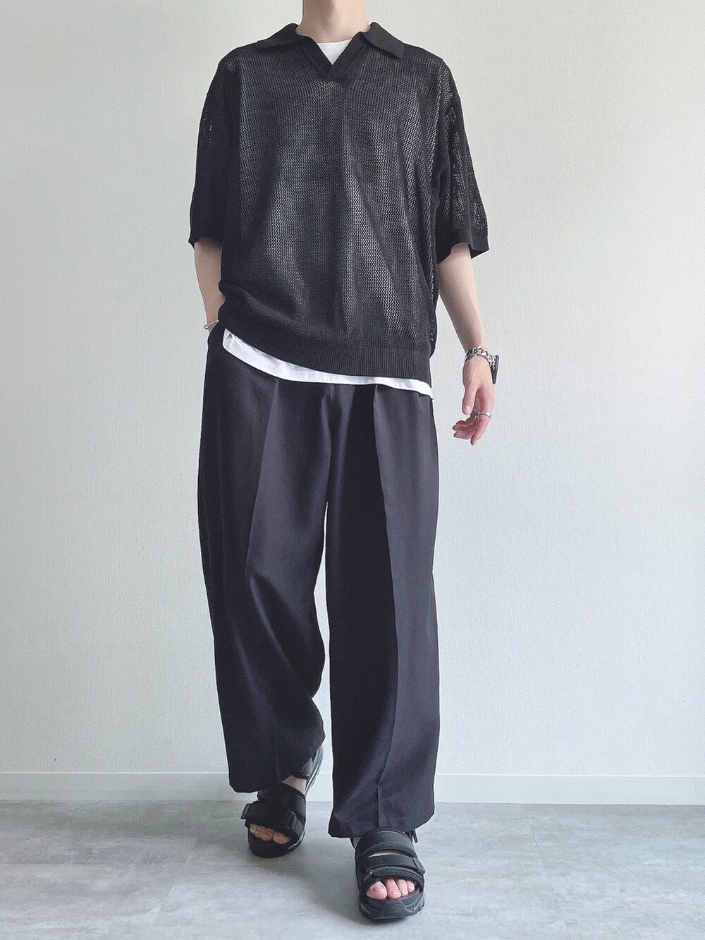 ブラック系のトップス、ホワイト系のタンクトップ、ブラック系のスラックスを着用したメンズの夏コーディネートの2枚目の写真