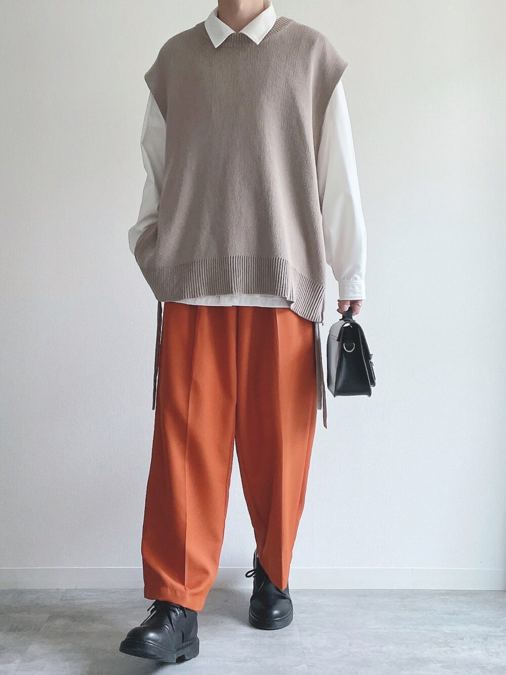 ベージュ系のベスト、ホワイト系のシャツ/ブラウス、オレンジ系のスラックスを着用したメンズの冬コーディネートの5枚目の写真