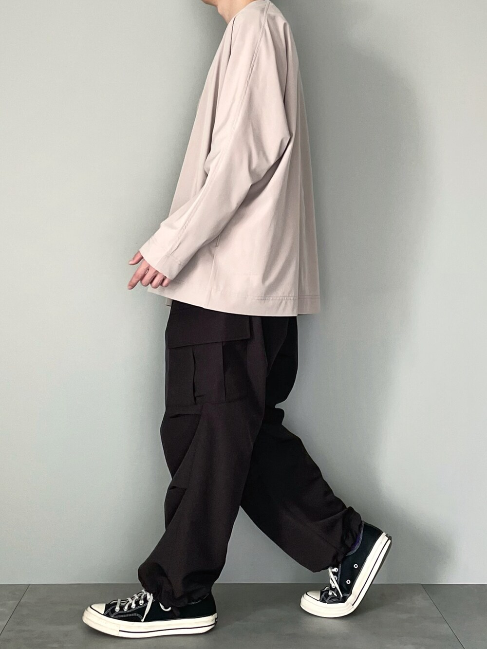 ベージュ系のカーディガン/ボレロ、ホワイト系のTシャツ/カットソー、ブラック系のカーゴパンツを着用したメンズの春コーディネートの3枚目の写真