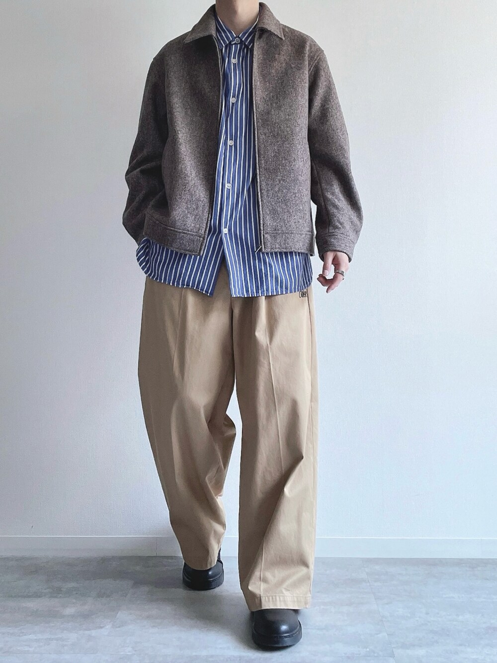 ベージュ系のジャケット/アウター、ブルー系のシャツ/ブラウス、ベージュ系のチノパンツを着用したメンズの冬コーディネートの2枚目の写真