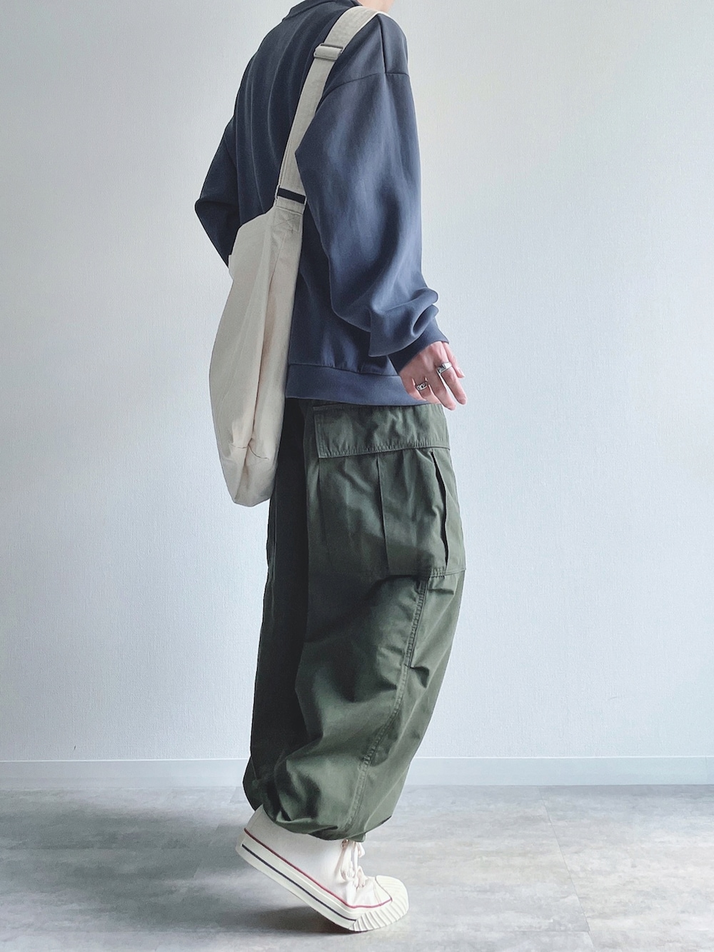 ブルー系のトップス、グリーン系のカーゴパンツ、ホワイト系のスニーカーを着用したメンズの秋コーディネートの4枚目の写真