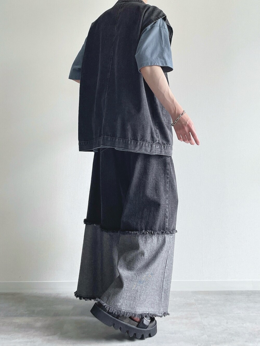 ブラック系のベスト、ブルー系のTシャツ/カットソー、ブラック系のデニムパンツを着用したメンズの夏コーディネートの4枚目の写真