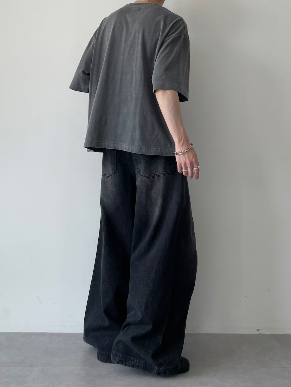 ブラック系のTシャツ/カットソー、ブラック系のデニムパンツ、ブラック系のスニーカーを着用したメンズの夏コーディネートの4枚目の写真