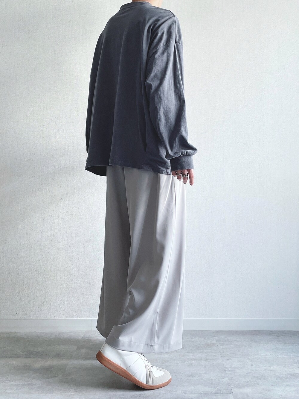 ブルー系のTシャツ/カットソー、グレー系のスラックス、ホワイト系のスニーカーを着用したメンズの秋コーディネートの4枚目の写真