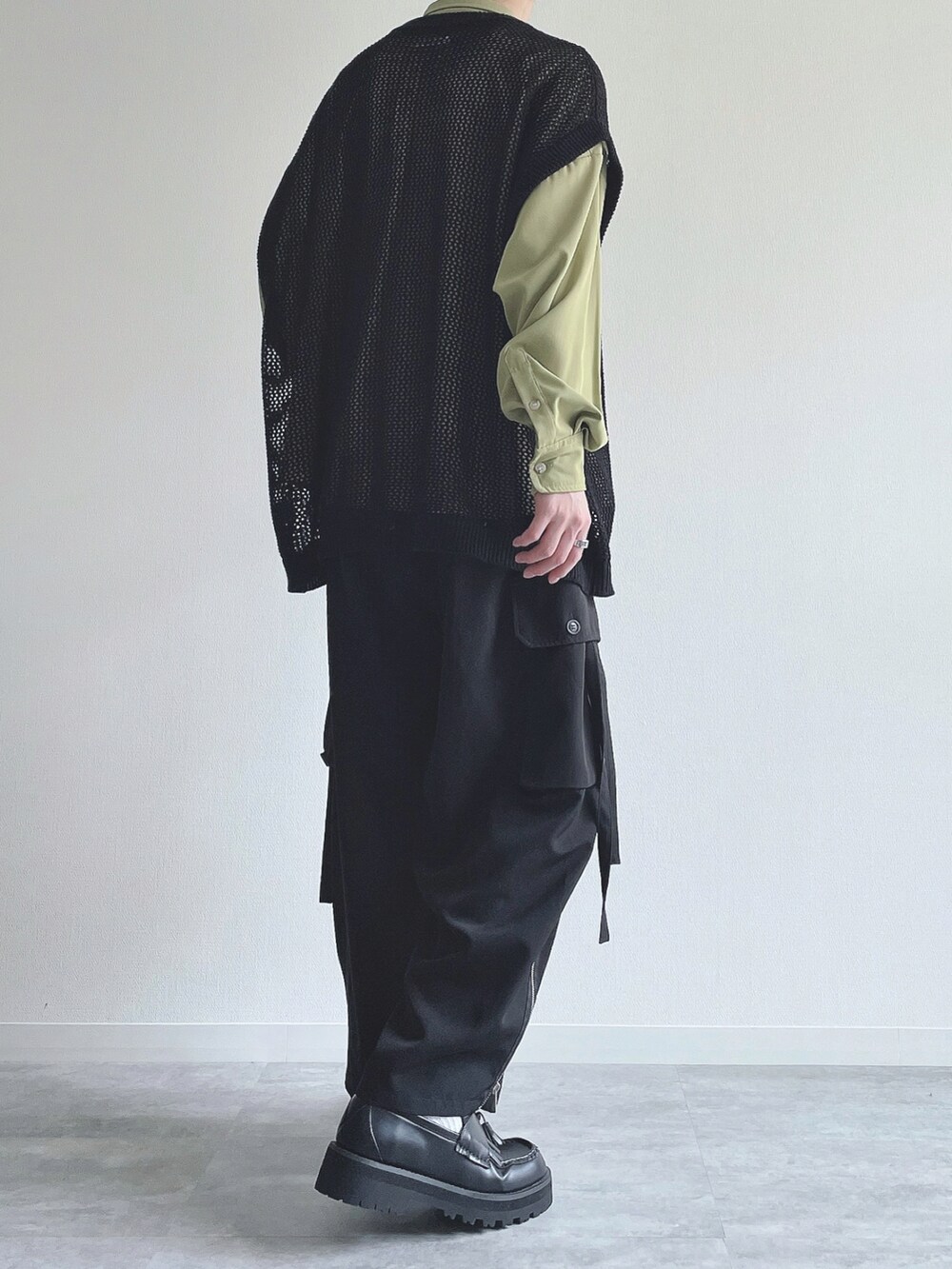 グリーン系のシャツ/ブラウス、ブラック系のベスト、ブラック系のカーゴパンツを着用したメンズの春コーディネートの3枚目の写真