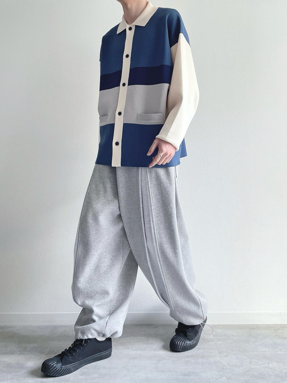 ブルー系のポロシャツ、グレー系のパンツ、ブラック系のスニーカーを着用したメンズの冬コーディネートの5枚目の写真