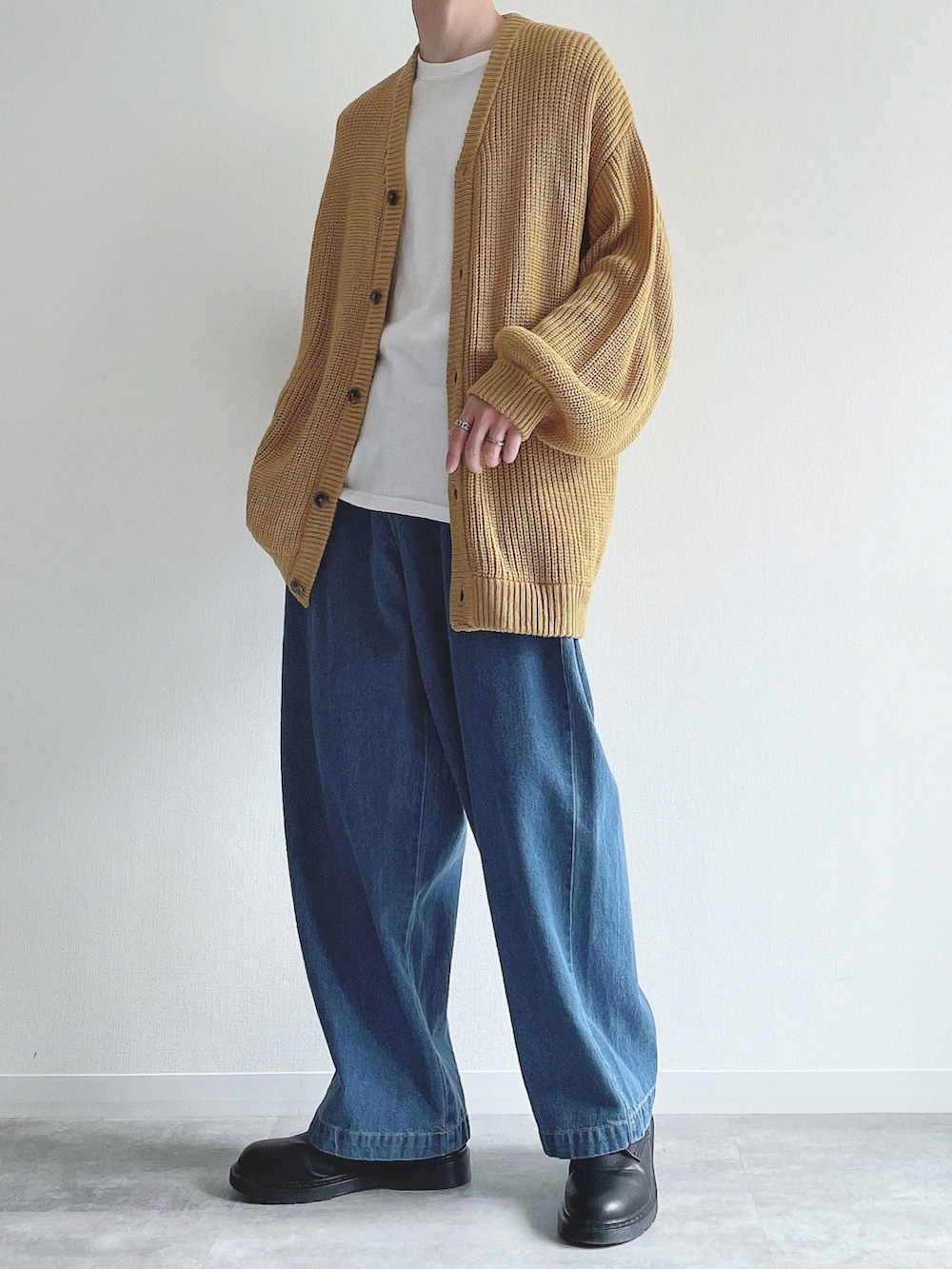 イエロー系のカーディガン/ボレロ、ホワイト系のTシャツ/カットソー、ブルー系のデニムパンツを着用したメンズの秋コーディネートの2枚目の写真