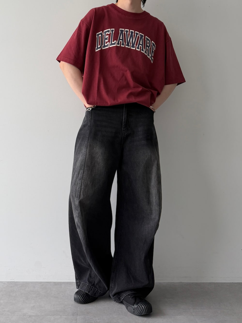 レッド系のTシャツ/カットソー、ブラック系のスニーカー、ブラック系のデニムパンツを着用したメンズの夏コーディネートの4枚目の写真