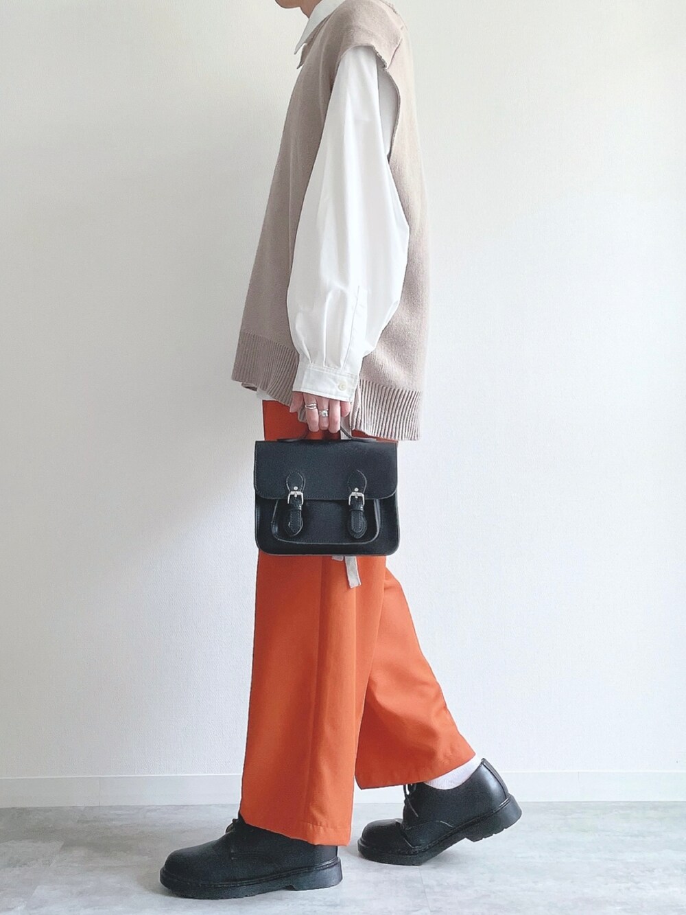 ベージュ系のベスト、ホワイト系のシャツ/ブラウス、オレンジ系のスラックスを着用したメンズの冬コーディネートの3枚目の写真