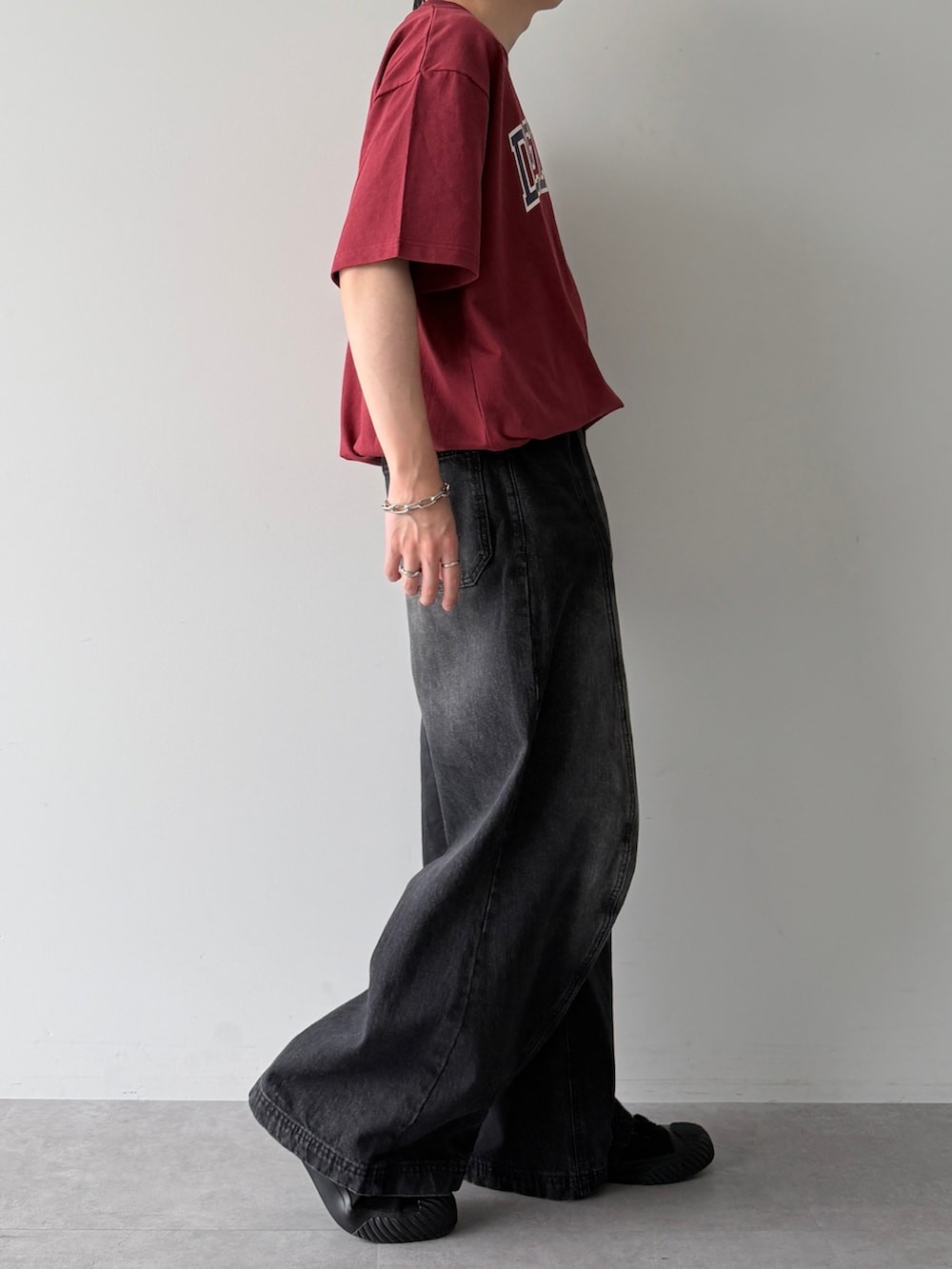 レッド系のTシャツ/カットソー、ブラック系のスニーカー、ブラック系のデニムパンツを着用したメンズの夏コーディネートの2枚目の写真