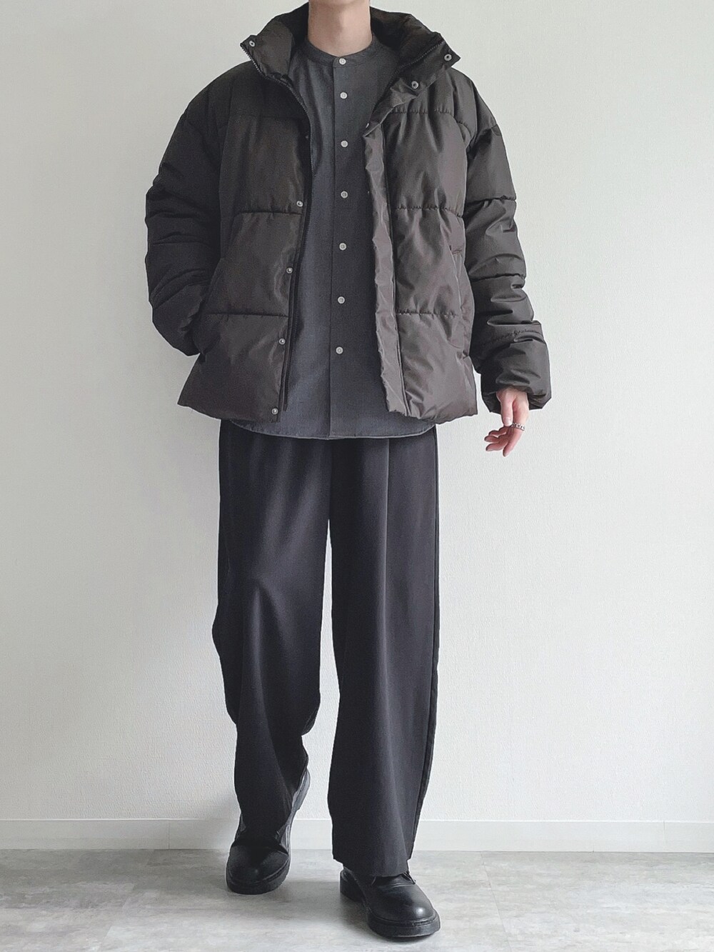 ブラック系のダウンジャケット/コート、ブラック系のトップス、ブラック系のスラックスを着用したメンズの冬コーディネートの4枚目の写真