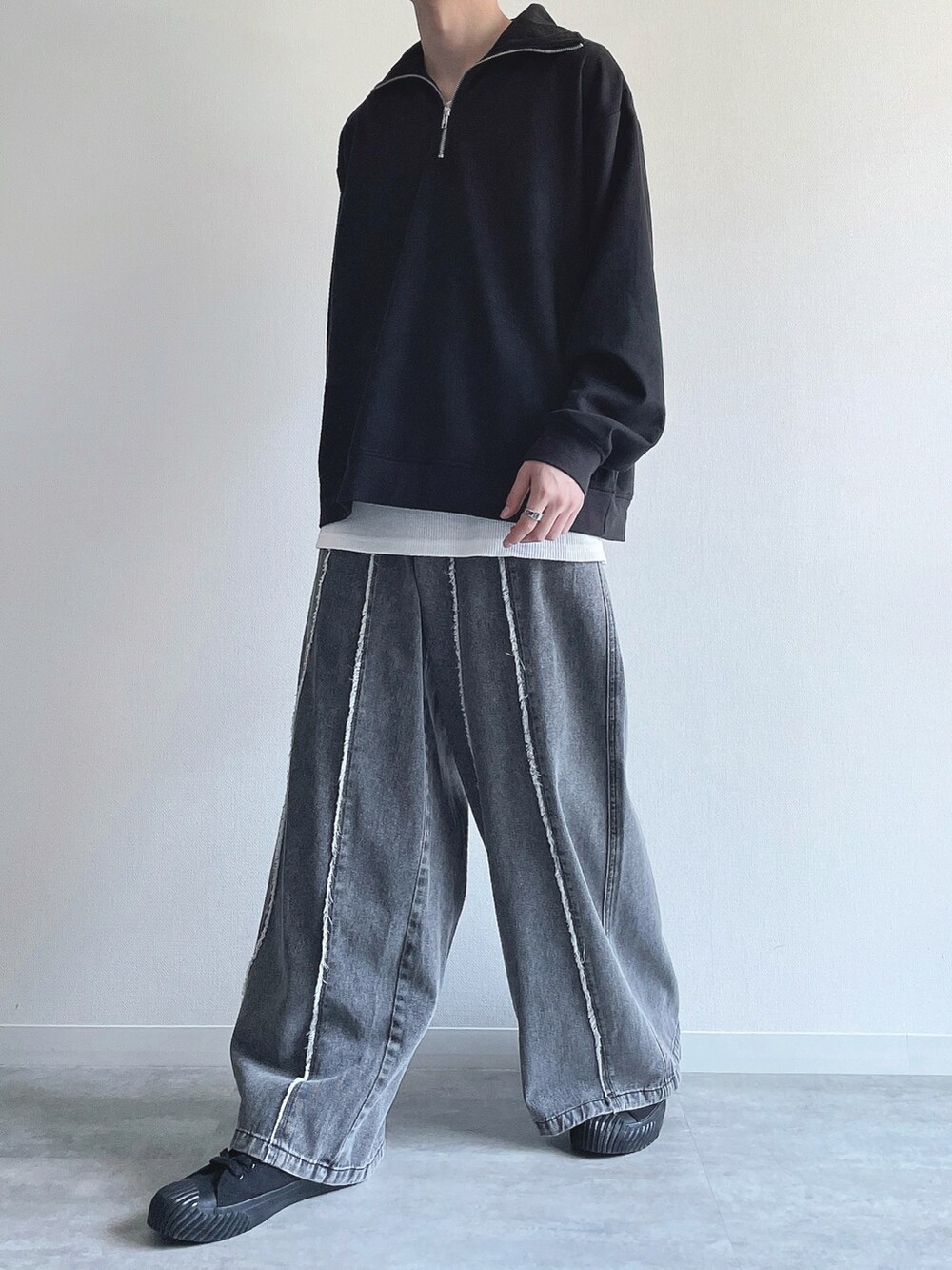 ブラック系のスウェット、ホワイト系のタンクトップ、グレー系のデニムパンツを着用したメンズの春コーディネートの5枚目の写真