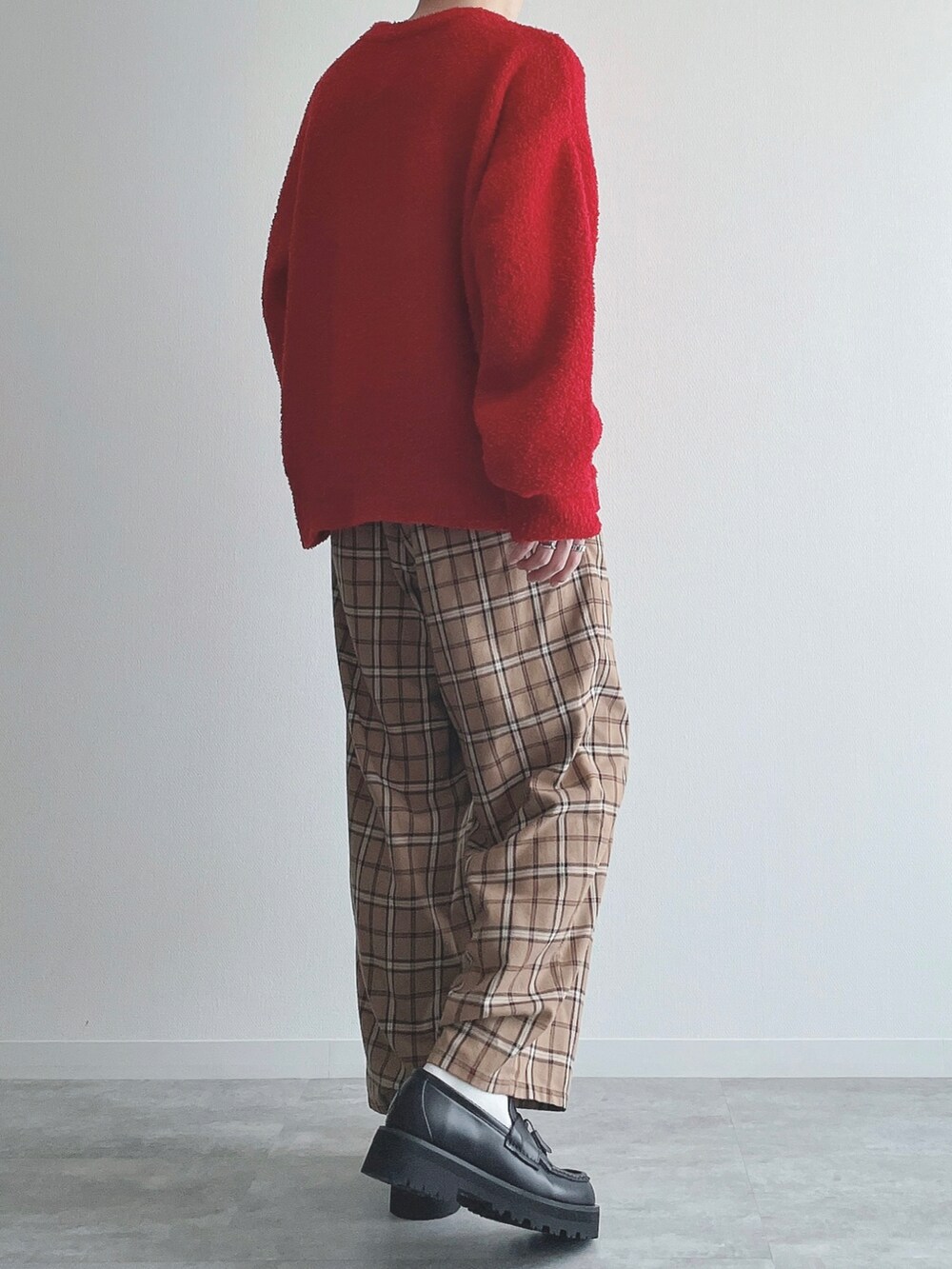 レッド系のニット/セーター、ベージュ系のその他パンツ、ブラック系のローファーを着用したメンズの秋コーディネートの3枚目の写真